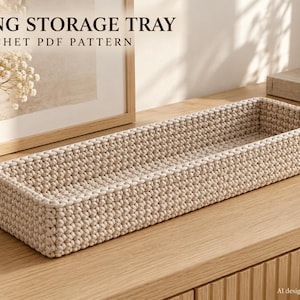 Può includere: Un vassoio portaoggetti lungo e rettangolare realizzato in filato beige lavorato all'uncinetto con un motivo a punti intrecciati e testurizzati. L'immagine include il testo LONG STORAGE TRAY CROCHET PDF PATTERN, indicando un modello digitale.