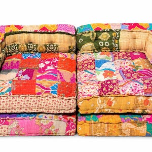 May include: A modular floor sofa composed of two square sections, each featuring a patchwork design of vibrant, multi-colored fabric squares in shades of pink, orange, yellow, green, and red, with tufted surfaces and raised back and side cushions.