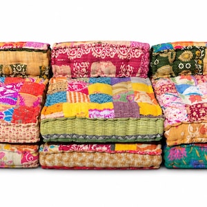 May include: A modular floor sofa composed of three rectangular sections, each featuring a patchwork design of various colorful fabrics. The cushions display diverse patterns in shades of pink, yellow, green, and orange, with stitched detailing.