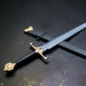 Peut inclure: Une épée en acier avec une lame à motifs, une poignée noire et des accents métalliques dorés sur le pommeau, la garde et le fourreau. Le fourreau noir présente des garnitures dorées à la pointe et à l'entrée, avec des gouttes d'eau.