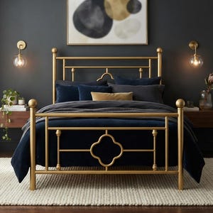 May include: A gold metal bed frame featuring a headboard and footboard with a central quatrefoil design, vertical posts with spherical finials, and horizontal support bars, dressed with dark navy blue bedding and pillows.