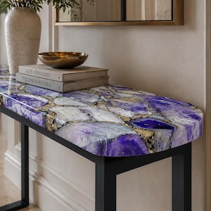 May include: A console table featuring a polished, semi-precious purple agate stone top with a mosaic of white, violet, and deep purple crystalline segments joined by gold-toned metallic veins, supported by a simple black metal frame.