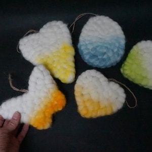 Könnte beinhalten: Fünf gehäkelte Herz- und Schmetterlings-Anhänger mit Ombre-Färbung in den Farben Gelb, Blau und Grün.
