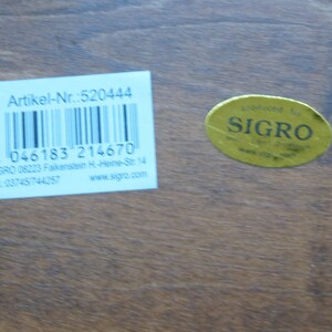 May include: A white label with black text and a barcode. The text reads "Artikel-Nr.:520444", "4 046183 214670", "SIGRO 08223 Falkenstein H-Heine-Str. 14", "Tel: 03745/744257", and "www.sigre.com". A yellow sticker with black text reads "SIGRO".