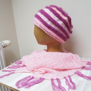 May include: A pink and purple striped knitted hat with a matching pink and purple fringed scarf.