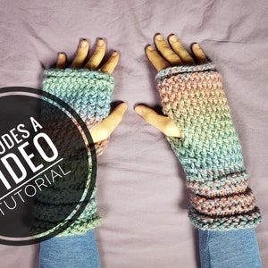 Puede incluir: Un par de guantes sin dedos de crochet de colores con un círculo blanco y negro que dice "Incluye un tutorial en video".