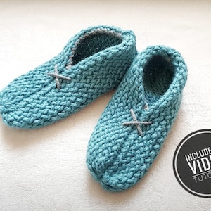 May include: A pair of teal blue knitted slippers with grey trim and a criss-cross design. Includes a video tutorial.
