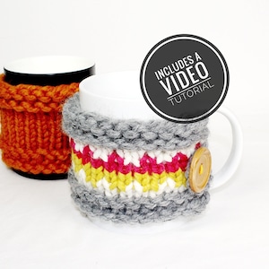 Puede incluir: Dos calientavasos de punto, uno naranja y otro gris con rayas blancas, amarillas y rosas. El calientavasos gris tiene un botón de madera. El texto "INCLUDES A VIDEO TUTORIAL" está en un círculo negro.