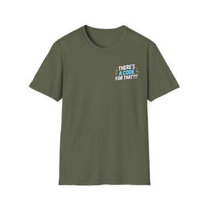 May include: An olive green short-sleeved t-shirt featuring a small graphic on the upper left chest. The graphic contains the text "THERE'S A CODE FOR THAT?!?" in white and light blue letters, surrounded by small yellow and white radiating lines.
