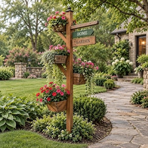 Pode incluir: Um poste de jardim vertical de madeira com quatro floreiras de madeira anexadas, cheias de flores cor-de-rosa e vermelhas e vegetação pendente. Uma placa de madeira horizontal pende do poste com o texto HOME e GARDEN em duas tábuas.