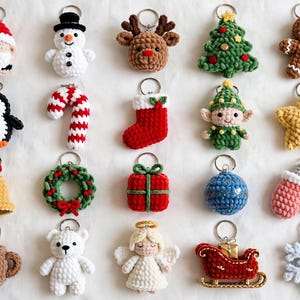 May include: A collection of twenty crocheted Christmas-themed keychains featuring various shapes including a Santa Claus, snowman, reindeer, tree, gingerbread man, penguin, candy cane, stocking, elf, star, bell, wreath, gift, ornament, mittens, mug, bear, angel, sleigh, and snowflake.