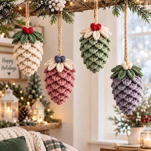 May include: Four hanging ornaments shaped like pinecones, crafted from crochet yarn. Each features a textured, layered design with a jute twine loop for hanging. The colors include cream, dusty pink, sage green, and lavender, topped with small berries.