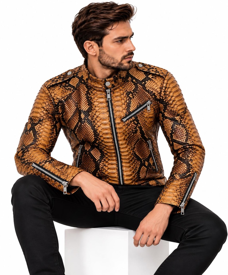 K&ouml;nnte beinhalten: Eine braun-schwarze Lederjacke mit Schlangenledermuster, Stehkragen mit Druckknopf, zentralem silbernem Rei&szlig;verschluss, zwei schr&auml;gen Brusttaschen mit silbernen Rei&szlig;verschl&uuml;ssen und Rei&szlig;verschl&uuml;ssen an den &Auml;rmelb&uuml;ndchen.