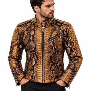 K&ouml;nnte beinhalten: Eine Jacke mit braun-schwarzem Schlangenledermuster, Stehkragen mit Druckknopf, durchgehendem silberfarbenem Rei&szlig;verschluss, einer schr&auml;gen Brusttasche mit Rei&szlig;verschluss, zwei unteren Rei&szlig;verschlusstaschen und Rei&szlig;verschl&uuml;ssen an den &Auml;rmelb&uuml;ndchen.