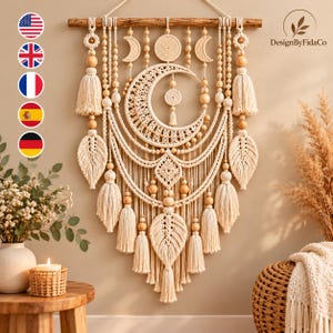 May include: A macrame wall hanging featuring a large central crescent moon, smaller moon phases, and leaf-shaped accents. The design incorporates natural cotton cord, wooden beads, and tassels suspended from a horizontal wooden dowel.