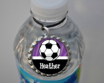 May include: A personalized water bottle charm with a purple, white, and black soccer ball design. The charm features the name "Heather" in white text.