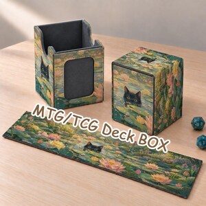 Può includere: Un set MTG/TCG Deck BOX con un gatto nero che spunta da uno stagno con ninfee rosa e foglie verdi. Il set include un contenitore aperto, una scatola chiusa con coperchio e un lungo tappetino rettangolare, tutti con illustrazioni coordinate.