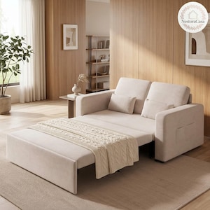 May include: A beige convertible sofa bed featuring a pull-out base, two back cushions, and two smaller throw pillows. The sofa is draped with a cream-coloured knitted throw blanket with a cable knit pattern, providing a neutral and functional seating piece.