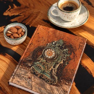 May include: A hardcover book featuring a detailed illustration of an ornate, weathered green clock on its cover, accompanied by a ceramic cup of black coffee on a saucer and a small bowl filled with brown almonds.
