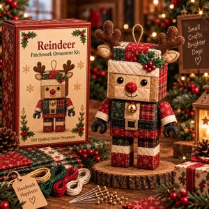 May include: A Reindeer Patchwork Ornament Kit box and a finished quilted fabric reindeer ornament. The ornament features a square head with brown felt antlers, a red nose, a gold bell, and a body made of red, green, and cream patterned fabric.