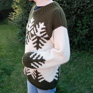 May include: A green and white crocheted sweater with a snowflake design.