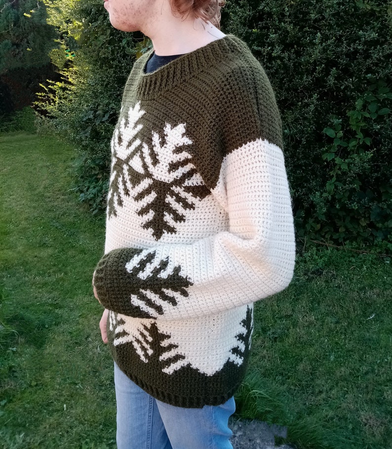 May include: A green and white crocheted sweater with a snowflake design.