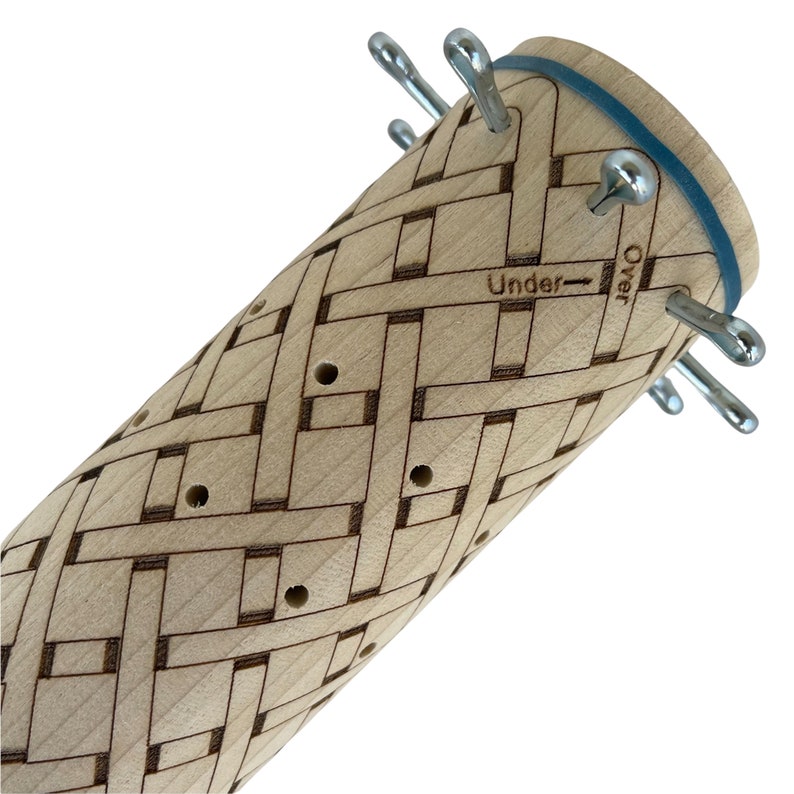 May include: A wooden knitting loom with a woven pattern and metal pegs. The loom has a blue rubber band around the top and the words "Over" and "Under" are printed on the side.
