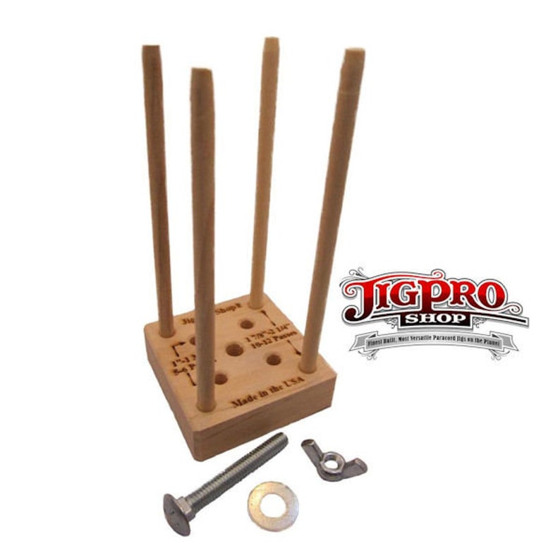 Puede incluir: Jig de madera con cuatro clavijas y una cuadr&iacute;cula de agujeros. El jig est&aacute; etiquetado con medidas en pulgadas y el texto "Made in the USA".