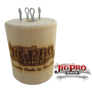Può includere: Un jig in legno con quattro ganci metallici, utilizzato per realizzare braccialetti in paracord. Il jig è inciso con le parole "JigPro Elite" e "Proudly Made in the USA".