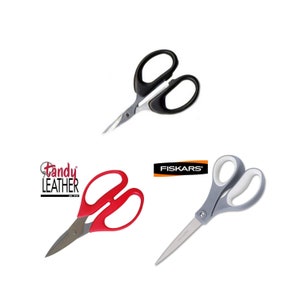 May include: Three pairs of scissors, one black with a silver blade, one red with a silver blade, and one gray with a white handle and a silver blade. The red scissors have the text "Tandy Leather" on them. The gray scissors have the text "Fiskars" on them.