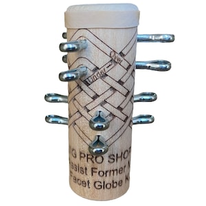Pu&ograve; includere: Una scatola di puzzle in legno con un motivo intrecciato e le parole "Over Under" incise sul lato. La scatola ha sei ganci di metallo che possono essere spostati per risolvere il puzzle. La scatola &egrave; etichettata "G Pro Shop" e "Facet Globe K" sul fondo.