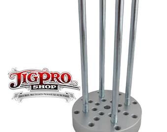May include: A silver metal jig with four metal rods extending upwards. The jig has a circular base with multiple holes. The jig is used for woodworking.
