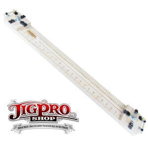 May include: A white wooden jig with a ruler marked in inches and a metal clamp at each end. The jig is labeled "JigPro Shop" and "Finest Built, Most Versatile Paracord Jigs on the Planet".