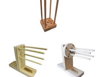May include: Three wooden dowel rod holders. The first holder is a square base with four dowel rods standing upright. The second holder is a vertical stand with three dowel rods. The third holder is a vertical stand with a round base and three dowel rods.