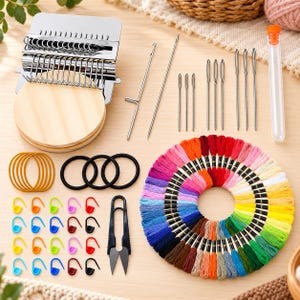 May include: A darning loom kit featuring a metal weaving tool with a round wooden base, various steel needles in a clear tube, a metal hook, multiple colorful embroidery thread skeins, black and yellow elastic bands, and plastic stitch markers.