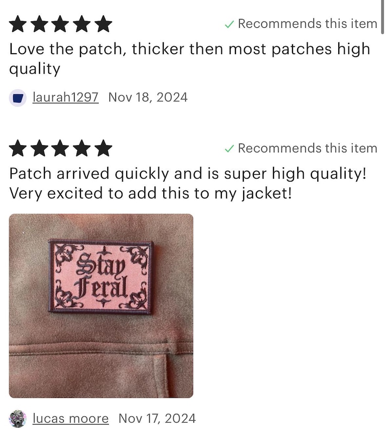 May include: A pink and black embroidered iron-on patch with the text "Stay Feral" in a gothic font. The patch is sewn onto a brown fabric jacket.