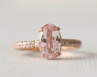 Anillo de compromiso de oro rosa de 14 quilates con zafiro ovalado color melocotón y diamantes.