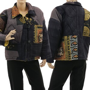 Könnte beinhalten: Eine gesteppte Jacke mit Patchwork-Design in Schwarz-, Grau- und Orangetönen. Das Kleidungsstück zeigt verschiedene Muster, darunter kreisförmige Motive, geometrische Formen und Paisley-Drucke. Sie hat einen Kragen, lange Ärmel und zwei Knöpfe auf der Vorderseite.