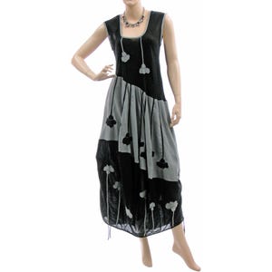 Könnte beinhalten: Ein ärmelloses Kleid in Schwarz und Grau mit einem Blumenmuster. Das Kleid hat eine lockere, fließende Passform und einen runden Ausschnitt.