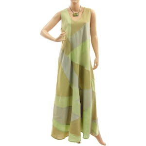 Könnte beinhalten: Ein ärmelloses, bodenlanges Kleid im Patchwork-Design. Das Kleid hat einen V-Ausschnitt und besteht aus verschiedenen Grün- und Beigetönen. Eine Halskette mit einem grünen Anhänger wird mit dem Kleid getragen.