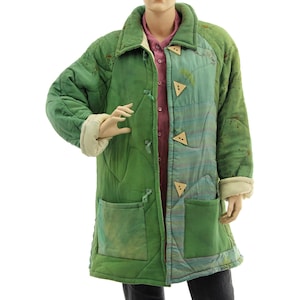 Könnte beinhalten: Ein gesteppter grüner Mantel mit Patchwork-Design. Der Mantel hat eine Mischung aus hell- und dunkelgrünen Stoffen, dreieckige Holzknöpfe und zwei Vordertaschen. Die Ärmel haben cremefarbene Manschetten.