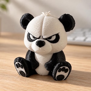 May include: A small, textured figurine of a seated panda with a grumpy facial expression. The panda has a white face, chest, and belly, with black ears, black patches around its eyes, black limbs, and black circular pads on its feet.