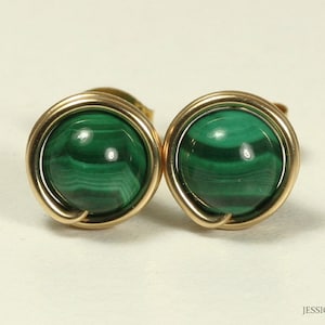 May include: A pair of gold wire wrapped earrings with green malachite stones.