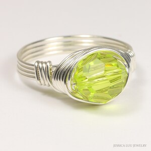 May include: A silver wire wrapped ring with a lime green faceted crystal.