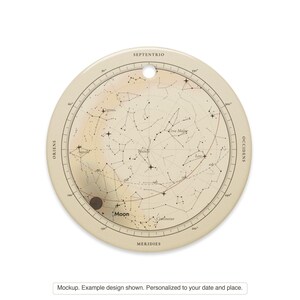 Printful mockup of the round ceramic star map ornament, front view with the hanging hole. Example design shown.