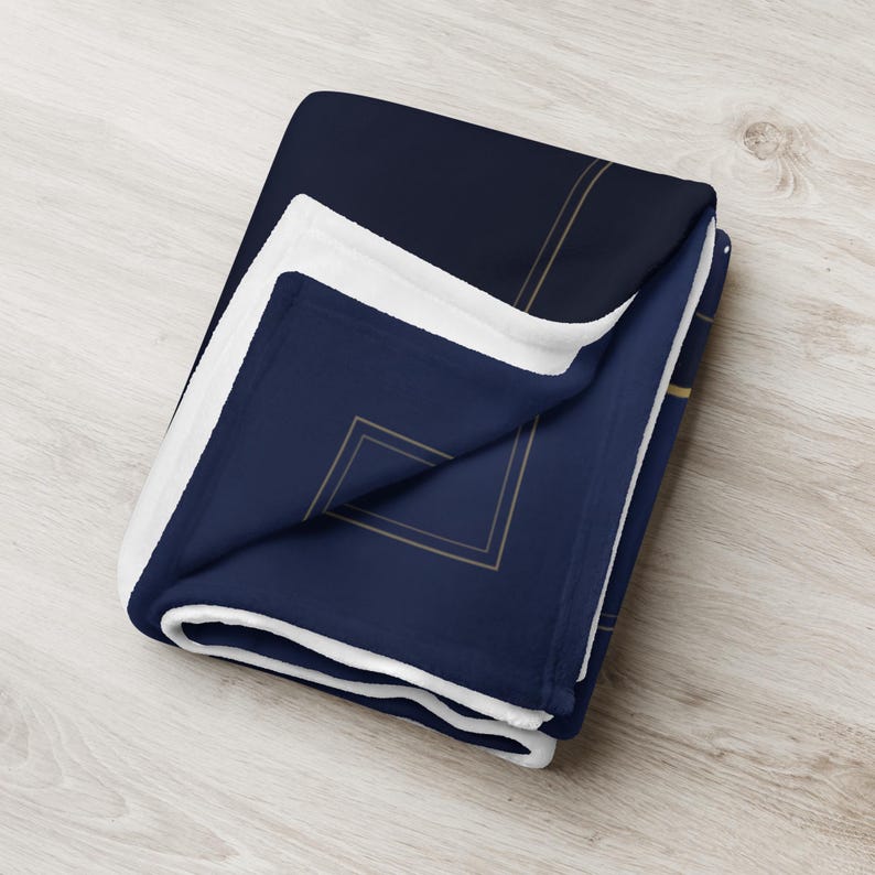 Printful mockup of the throw blanket folded, showing the soft white back.