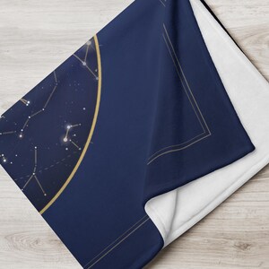 Close detail of the printed star map and the soft white back of the throw blanket.