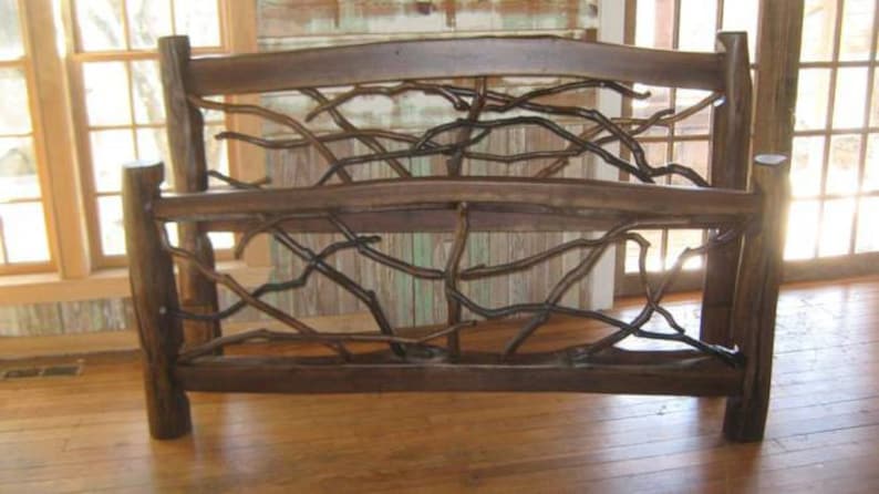 May include: A wooden bed frame with a unique design featuring branches woven into the headboard and footboard. The frame is dark brown and has a rustic, natural look.