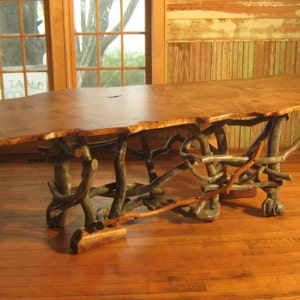 Beautiful single slab live edge maple dining table with natural organic base.