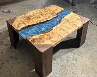Burl maple slabs with blue swirl epoxy river. Mitered walnut legs.